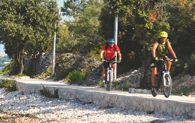 Cyklisti na cestičke pri morskom pobreží v Privlake. Cyklovýlety v Chorvátsku sú obľúbené, táto lokalita to len potvrdzuje.